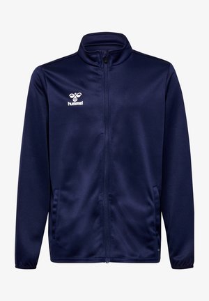 Námořnická modrá zipová bunda vyrobená z hladkého materiálu, s límcem, bočními kapsami a bílým logem Hummel na hrudi.