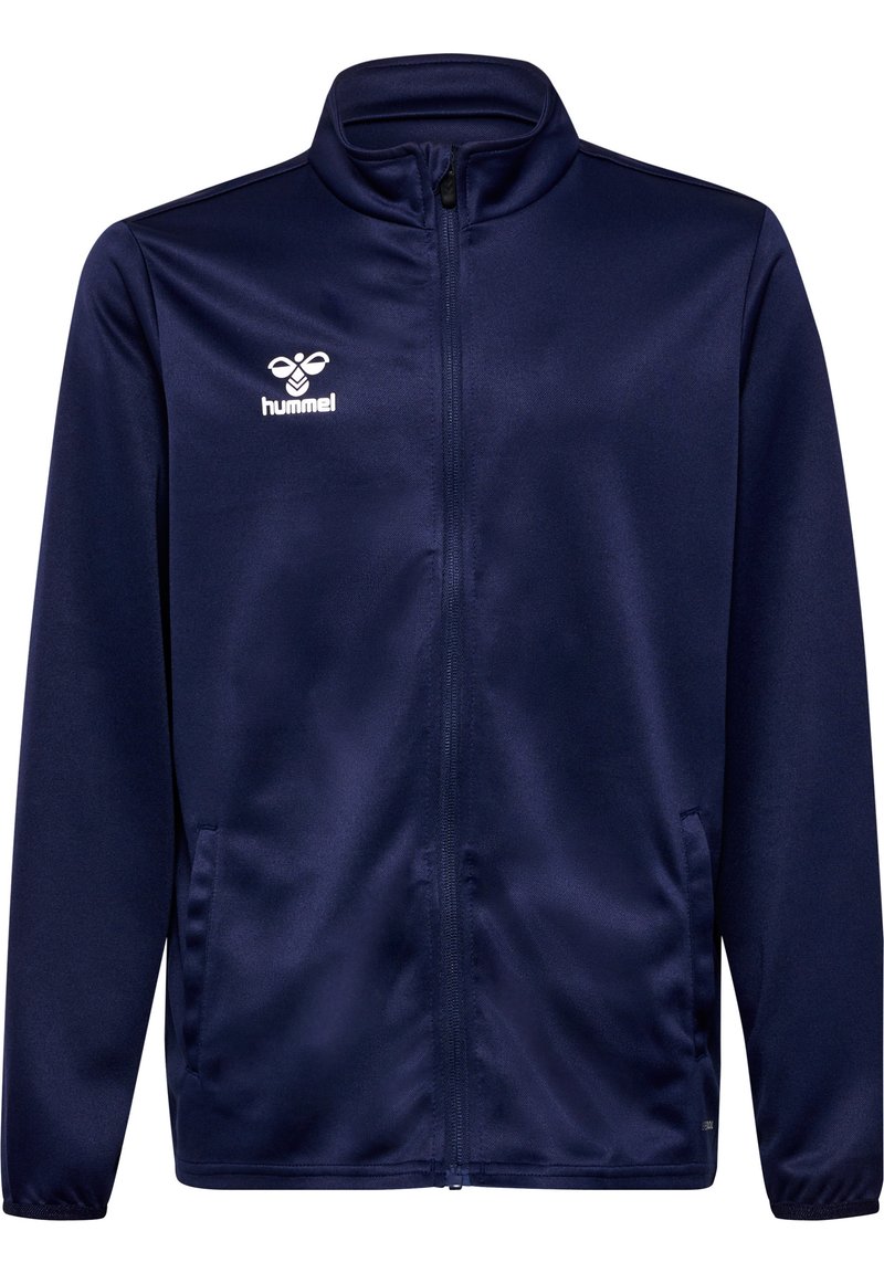 Marineblå zip-up jakke laget av glatt stoff, med oppreist krage, sidelommer, og en hvit Hummel-logo på brystet.