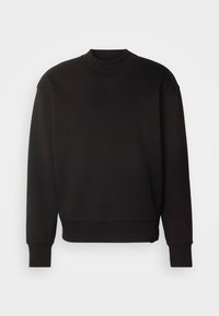 Felpa nera realizzata in un materiale morbido e elasticizzato. Caratterizzata da un collo alto, spalle scese, maniche lunghe e un orlo leggermente accorciato.