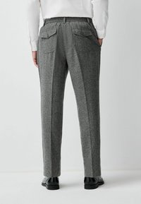 Gray tweed trousers with a textured finish, elastic waistband, and two back pockets. Straight-leg design with a pressed crease detail.