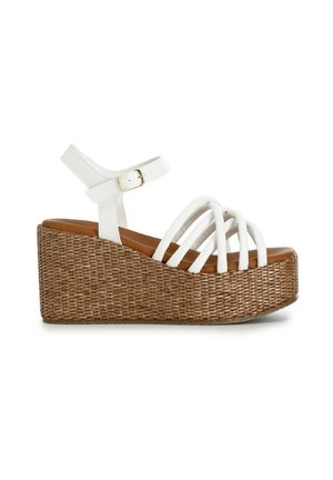 Sandali con zeppa bianchi che presentano una piattaforma intrecciata marrone, molteplici cinghie bianche e una cinghia alla caviglia con fibbia. Superficie liscia e base texturizzata.