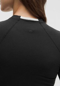 Must mustreppidega must topp ümara kaelusega, raglanvarrukatega ja väikese logodetailiga seljal. Sile ja kerge kangas.