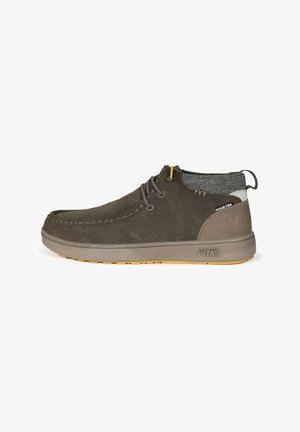 Chaussons d'ankle en suède marron avec des accents en tissu gris, à bout rond, deux trous pour les lacets, semelle en caoutchouc texturée et logo sur le talon.