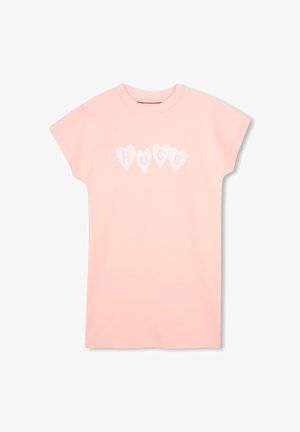 T-shirt en coton rose à manches courtes, avec un motif en forme de cœur blanc et le mot "HUGO" au centre. Encolure ronde classique.