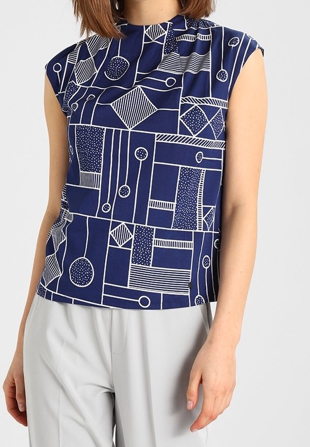 Navy blue sleeveless top featuring a geometric white pattern with circles, lines, and shapes. Smooth fabric with a round neckline.