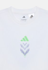 Hvid kortærmet t-shirt med grøn og lilla chevron grafisk logo på forsiden, med ribbet rund hals og label indeni.