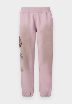 Pantalon de survêtement rose avec une taille élastique, présentant des patches décoratifs en forme de diamant sur le côté gauche et des poignets élastiques aux chevilles.