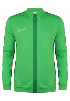 Grüne Nike Sportjacke mit durchgehendem Reißverschluss, langen Ärmeln, Seitentaschen, gerippten Bündchen und einem weißen Nike-Logo auf der linken Brust.