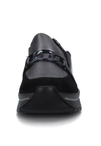 Scarpa da ginnastica nera caratterizzata da una combinazione di pelle liscia e morbida in suede. Dettagli distintivi con cinturino e suola texturizzata, forma della punta arrotondata.