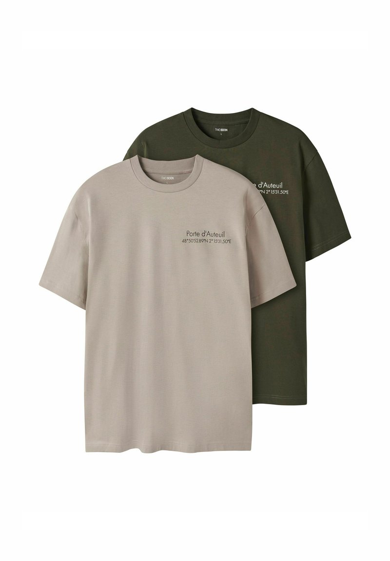 Två bomulls-t-shirts: en beige och en mörkgrön. Båda har korta ärmar och rund halsringning, med tryckt text på framsidan.