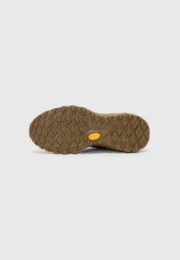Brun gummisåle med detaljerte gripe mønstre, som har heksagonale og triangulære dekk for grep; inkluderer en gul Vibram-logo.