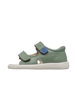 Sandalo verde per bambini piccoli con due cinturini regolabili in velcro, dettaglio a linguetta blu, ritagli ai lati e suola in gomma bianca.