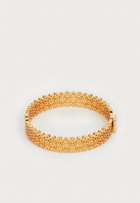 Gullfarget armbånd med intrikate utskårne blomsterdesign, glatte kanter og en sikker lås, med et lett, metallisk design.