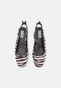 Hnedé a biele slingback topánky so vzorom zebry, s plochým opätkom, zaoblenou špičkou a hladkým čiernym vnútorným podšívaním.