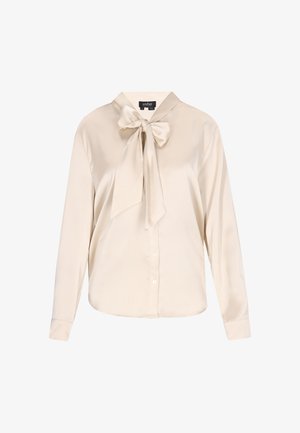 Beżowa satynowa bluzka z długimi rękawami, kołnierzem i dużą kokardą przy szyi. Zapięcie na guziki z przodu.