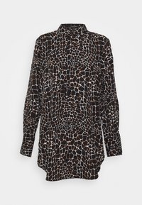 Chemise noire à manches longues avec boutons, motif irrégulier blanc et marron rappelant celui d'une girafe, et col pointu.