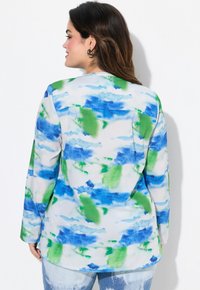 Blusa a maniche lunghe con un motivo astratto multicolore in blu e verde su uno sfondo chiaro, realizzata in tessuto morbido con una vestibilità rilassata.