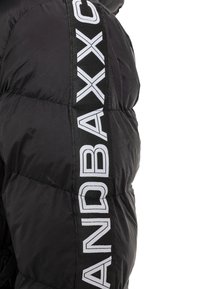 Schwarze Daunenjacke mit gesteppten Abschnitten, ausgestattet mit einem Seitenpanel mit fetter, weißer Schrift. Glatte Stoffoberfläche und sportliches Design.