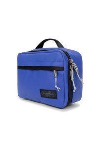 Blå nylonväska med rektangulär form, svart dragkedja, framficka och grå detaljer. Utrustad med ett handtag på toppen för enkel bärning.