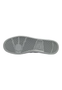 Nike shoe sole in light gray rubber, featuring a textured pattern of circular grips and a checkered section with a logo accent.