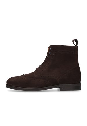 Stivaletto alla caviglia in pelle scamosciata marrone scuro con dettagli brogue, chiusura frontale con lacci, linguetta sul tallone e suola bassa nera.