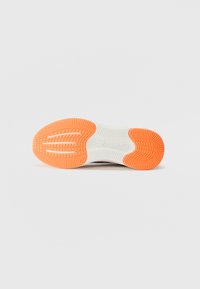Shoe sole with a textured design, featuring white rubber and bright orange accents. The sole has pronounced grooves for grip and traction.