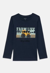 Marineblaues Langarmshirt mit einem gelben Traktor-Graphic, dem Text "FARM LIFE" und landwirtschaftlichen Motiven in Grün und Schwarz. Aus weichem Baumwollmaterial.
