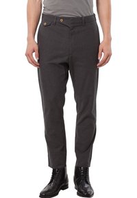 Grå byxor med skräddarsydd passform, med platt framstycke, två framfickor och en enkel knappstängning. Kombinerade med svarta läderstövlar.