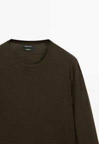 Dunkelgrünes Langarm-T-Shirt aus weichem Stoff, mit einem runden Ausschnitt und minimalistischem Design, mit einem sichtbaren Markenetikett auf der Innenseite.
