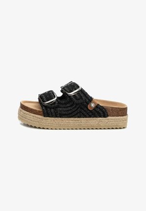 Sandalias tejidas negras con dos hebillas ajustables, plantilla de corcho y suela de yute gruesa y texturizada. Presenta un acento de logo redondo en el costado.