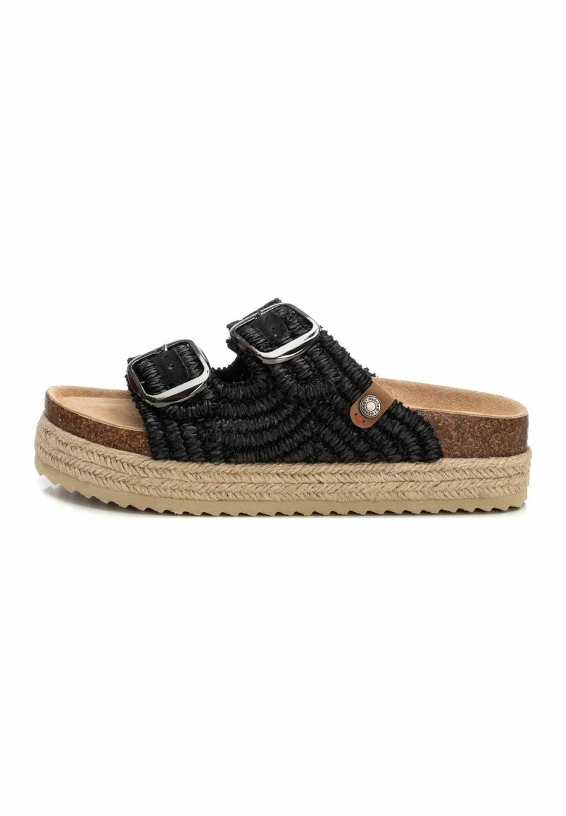Sandalias tejidas negras con dos hebillas ajustables, plantilla de corcho y suela de yute gruesa y texturizada. Presenta un acento de logo redondo en el costado.