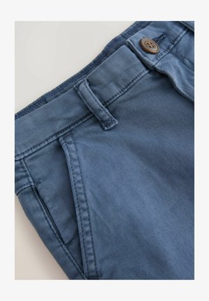 Blå bomuldsbukser med en glat tekstur, der har en knaplukning og bæltestropper, skrå sidelommer og kontrastsyninger.