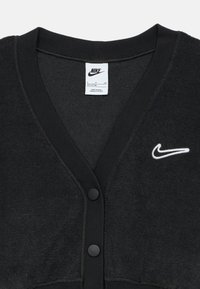 Czarny kardigan z dekoltem w serek, fakturowana tkanina, prążkowany dekolt i mankiety, z białym logo Nike i czarnymi guzikami.