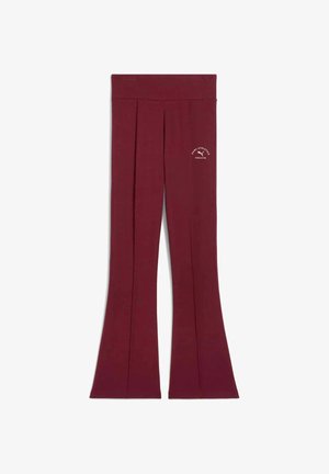 Leggings acampanados burdeos con una cinturilla ancha y un pequeño logo blanco en la parte inferior izquierda. Fabricados con una tela suave y lisa.