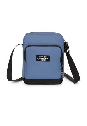 Kleine blaue Eastpak Umhängetasche mit schwarzem Boden, vorderer Reißverschlusstasche und verstellbarem schwarzem Schultergurt vor weißem Hintergrund.