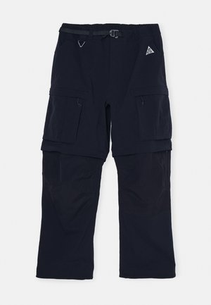 Navy cargo pants made of durable fabric, featuring a belt with buckle, multiple pockets, and a blended texture with smooth and ripstop areas.