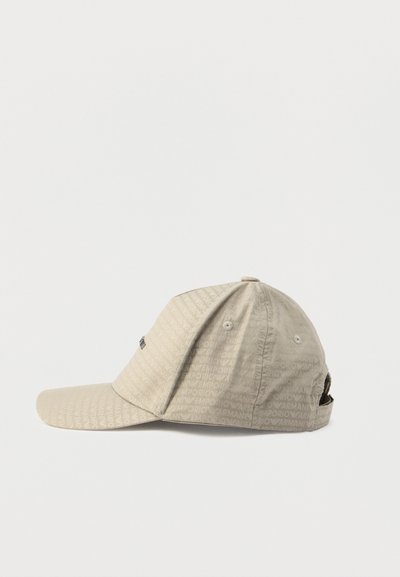 Bēšs cepure ar izliekumu. Ar atkārtotu logotipa rakstu. Izgatavota no viegla materiāla, ar sānu ventilācijas caurumu un regulējamu siksnu.