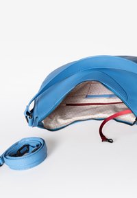 Blauwe leren tas met een gladde afwerking, ritssluiting aan de bovenkant en een gevoerde stof met patroon die een rode accentkleur heeft en binnenzakken bevat. Inclusief bijpassende schouderband.