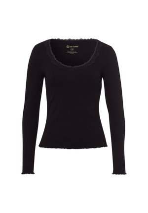 Top negro de manga larga con textura acanalada, escote con volantes y fruncido en los puños. Etiqueta visible en el interior del escote.