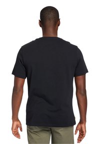 Camiseta de algodón negra con mangas cortas, escote redondo y dobladillo recto. Presenta un diseño minimalista sin patrones ni gráficos visibles.