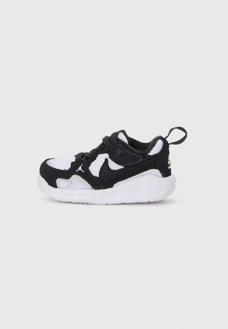 Baskets de sport en noir et blanc avec des matériaux en maille et en daim, bout rond, semelle texturée et une languette au talon.