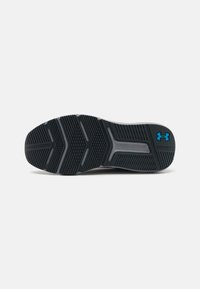 Sort sneakersål med tekstureret, mønstret gummi. Har fremtrædende trækkrog og blåt Under Armour-logo. Glatte kanter.