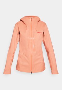 Jachetă impermeabilă de culoare coral deschis pentru femei, cu glugă, fermoar pe toată lungimea frontală, două buzunare verticale pe piept și logo-ul "Patagonia" pe pieptul stâng.