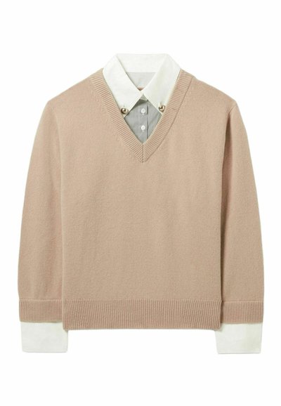 Pull en V en tricot beige doux avec un ourlet et des poignets côtelés, comportant une chemise col blanc en dessous avec de fines rayures et des boutons décoratifs.