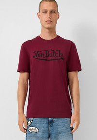 Bordo pamučna majica s velikim crnim "Von Dutch" logotipom na prsima. Dizajn s običnim ovratnikom i kratkim rukavima.