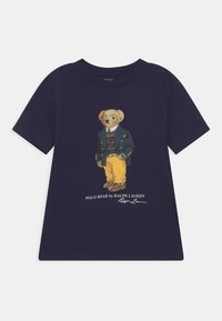 Navy blue t-shirt with a graphic of a bear wearing a green jacket, striped sweater, yellow pants, and brown shoes, with Polo Bear text below.