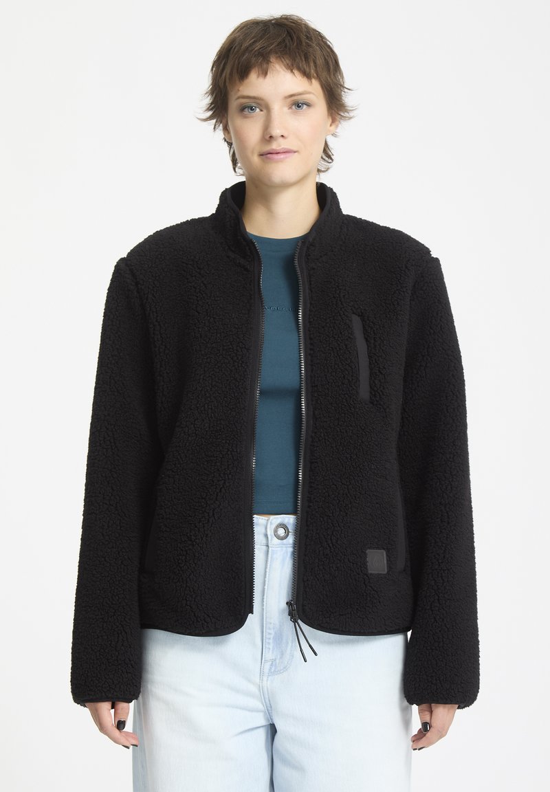 Giacca in pile nera con zip frontale, tasche laterali e un logo ricamato discreto. Presenta un tessuto testurizzato con una finitura morbida e polsini elastici.