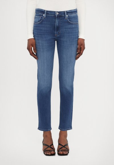 Mellemfarget denim jeans med lige ben, fem lomme-design og subtil falmning. Sammen med sorte strop sandaler.