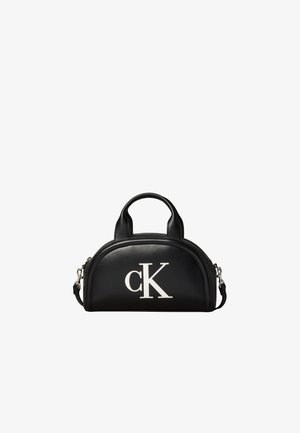 Petit sac à main en cuir noir avec deux petites poignées, bandoulière amovible et grand logo blanc "cK" sur le devant.