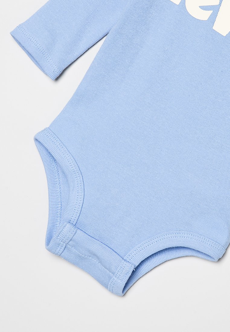 Mono de algodón azul claro con mangas largas. Presenta un cuello redondo, una textura suave y un gráfico impreso en blanco en el frente.